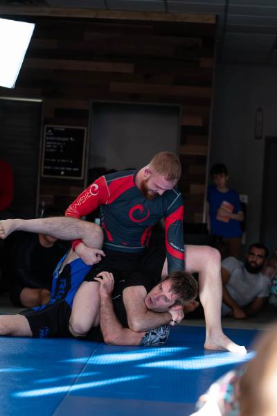bjj match: player on top has their opponent in a gift wrap